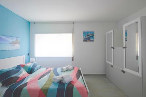 a bedroom with a bed with a colorful blanket at Sul mare in centro con 2 camere e posto auto a novembre in Pescara