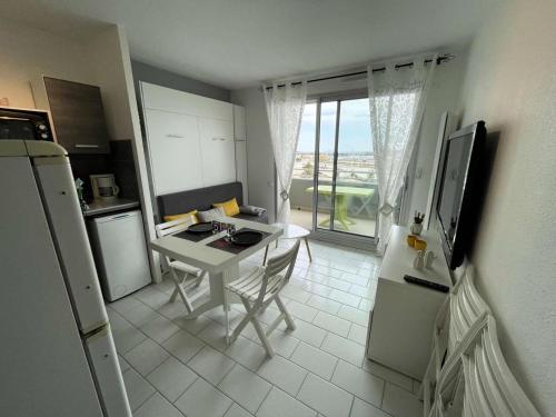 une petite cuisine avec une table et un réfrigérateur dans l'établissement Résidence Les Marines - PORNICHET APAPRTEMENT FACE MER MAE-8801, à Pornichet