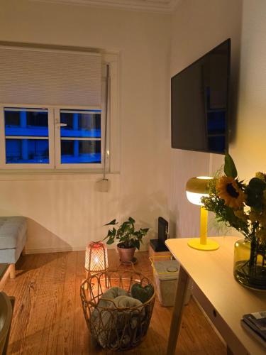 a living room with a table and a tv on the wall at Majesticlara Lisbon Guest House in Lisbon