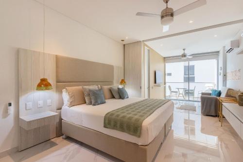 une chambre avec un grand lit et un balcon dans l'établissement U-GO Sui Loft : Luxe et Confort face à la Mer à Santa Marta, à Playa Bello Horizonte