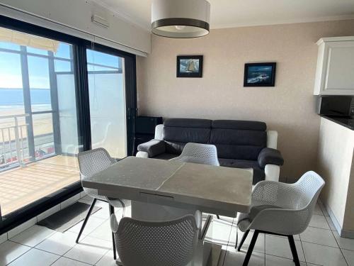 un salon avec une table, des chaises et un canapé dans l'établissement Résidence L'amiral B - Location de Vacances - PORNICHET -APPARTEMENT FACE MER MAE-1801, à Pornichet