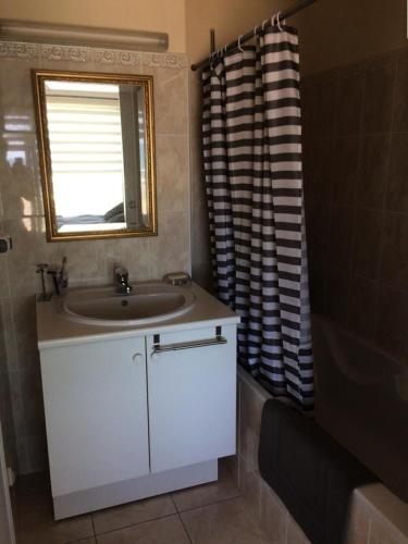 une salle de bain avec un lavabo et un rideau de douche dans l'établissement Résidence L'amiral B - Location de Vacances - PORNICHET -APPARTEMENT FACE MER MAE-1801, à Pornichet