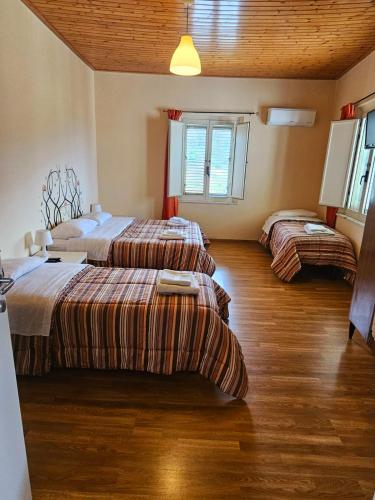 two beds in a room with wooden floors at Home Sweet Home Galatro in Galatro