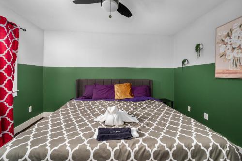 a bedroom with a large bed with purple and green walls at Modern Quirky Apartment Near Medical Center in Houston