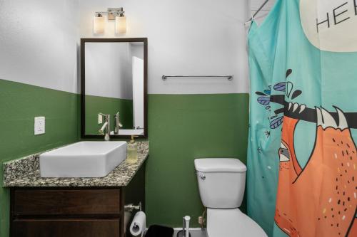 a green bathroom with a sink and a toilet at Modern Quirky Apartment Near Medical Center in Houston