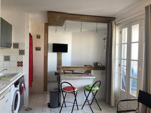 - une cuisine avec deux tabourets et une table dans l'établissement Résidence Les Marines - PORNICHET - Appartement face mer pour 4 personnes MAE-0511, à Pornichet