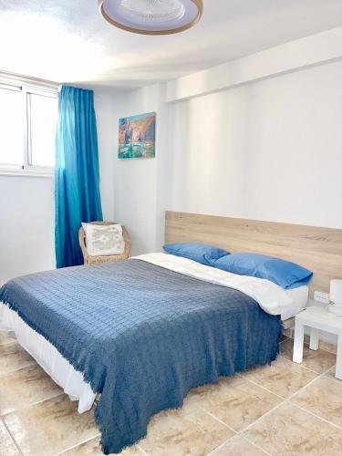 a bedroom with a large bed with a blue blanket at Copacobana Ocean View Playa Las Americas in Costa de Adeje