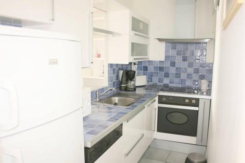 une cuisine blanche avec un évier et une cuisinière dans l'établissement Résidence Le Breiz Avel - PORNICHET FACE MER - T3 FACE MER PROCHE CASINO MAE-8311, à Pornichet