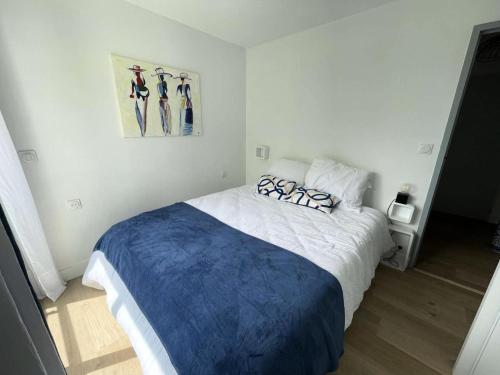 une chambre avec un grand lit avec des draps bleus et blancs dans l'établissement Résidence Le Deauville - Pornichet - Appartement proche Hippodrome MAE-2291, à Pornichet