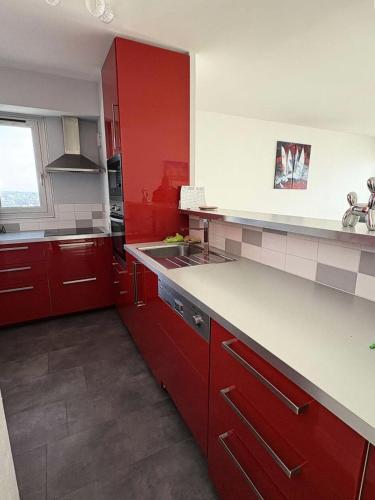 une cuisine avec des armoires rouges et un évier dans l'établissement Résidence La Louisiane - LA BAULE - IMMEUBLE EN VAGUES - FACE MER MAE-5181, à Mazy