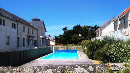 - une piscine dans une cour à côté d'un bâtiment dans l'établissement Résidence Salar-61-pornichet - Location de Vacances - PORNICHET - Sublime appartement FACE MER MAE-6941, à Pornichet