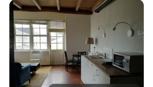 cocina con microondas y mesa con sillas en NAMOR-Estudio Galeria, en Ribadeo