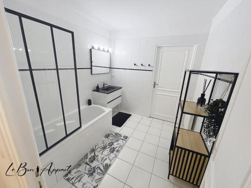 une salle de bain blanche avec une baignoire et un lavabo dans l'établissement Le Bon'Appart au Cœur de Saumur, à Saumur
