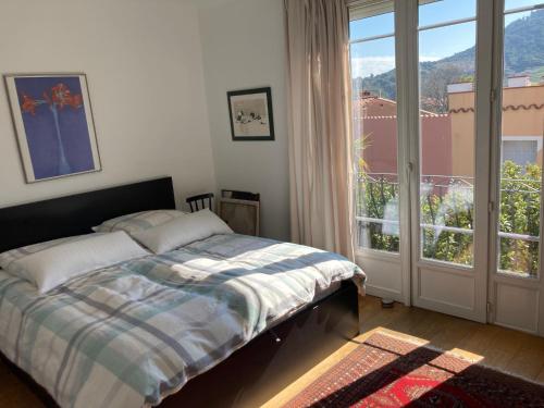 une chambre avec un lit et une grande fenêtre dans l'établissement Komfortables Haus mit zwei Terrassen, à Collioure