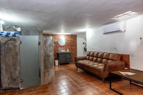 a living room with a couch and a table at Suite Subterránea con AC, de 2 Niveles Chapalita 6 in Guadalajara