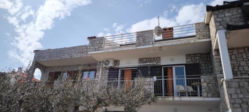 a house with a balcony and a sky at Apartman None in Stomorska