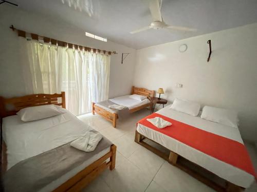 a bedroom with two beds and a window at Finca Ecoturistica San Javier in Ibagué