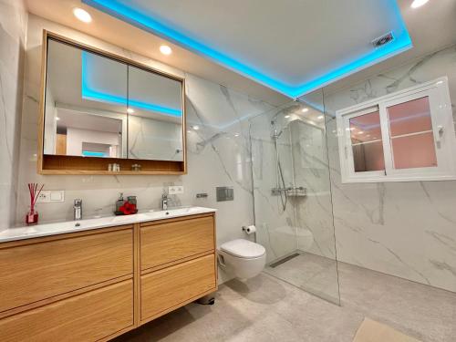 a bathroom with a toilet and a sink and a shower at Sunset Apartment 5 & Heated Pool in Los Cristianos