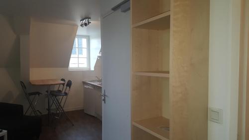 a room with a closet with a desk and a table at Au Pigeon Blanc in Andouillé