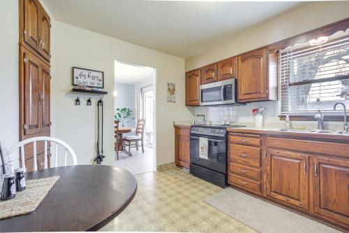 a kitchen with wooden cabinets and a stove top oven at Walk to Lake Family Getaway with Yard in Menasha! in Menasha