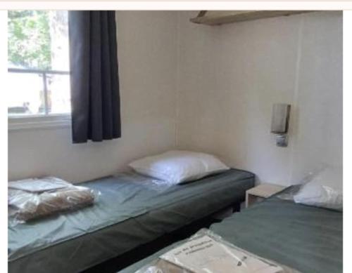 deux lits jumeaux dans une chambre avec fenêtre dans l'établissement Camping marvilla MH 253, à Agde