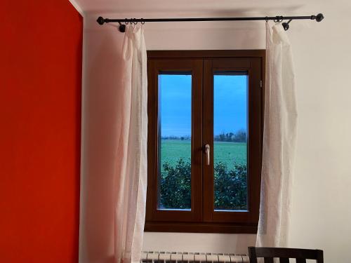 a window with a view of a green field at Casa di Gabry in Gradisca dʼIsonzo