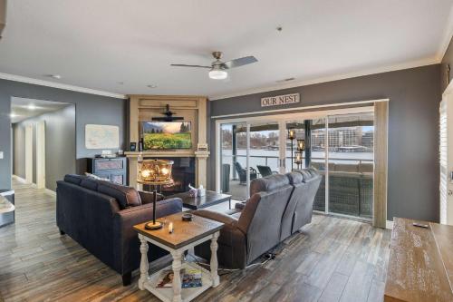 a living room with couches and a table at Lakefront 4BR Luxury Sleeps 13 Pool & Hot Tub in Lake Ozark
