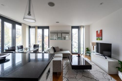 a living room with a couch and a table at Modern, fully furnished apartment with ensuite, private balcony and elevator in Notting Hill in London