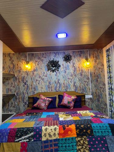 a bedroom with a bed with a colorful quilt on it at Laxmi Narayan Homestay-Harshil in Harsil