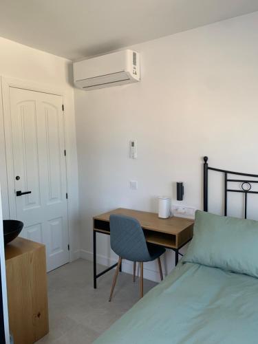 a bedroom with a bed and a table and a desk at Torre de Santa María in Utrera