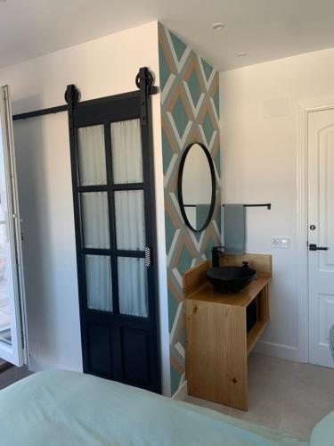 a bathroom with a black door and a mirror at Torre de Santa María in Utrera