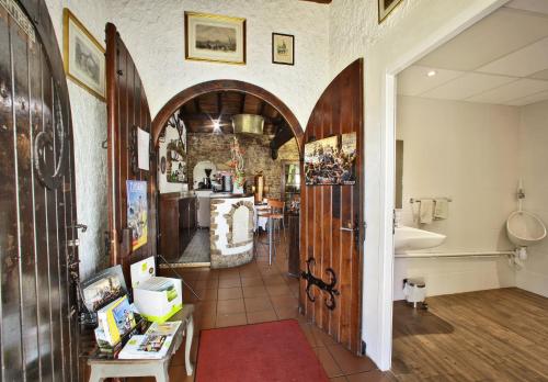a kitchen with an archway and a bathroom with a sink at Logis Hôtel La Chaumière in Saint-Laurent-sur-Sèvre