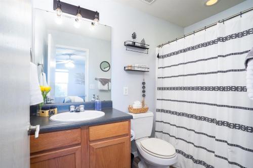 Un baño con lavabo, inodoro y cortina de ducha. en 3 BR VY2901-5, Sleeps 11, Between Strip & SDC, en Branson