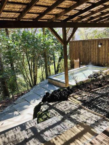 a patio with a swimming pool and a wooden fence at Hakonesaryo Kintoki in Hakone