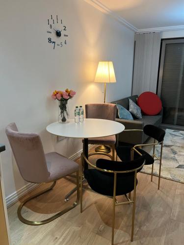 a living room with a table and chairs and a couch at North Acton Flat in London
