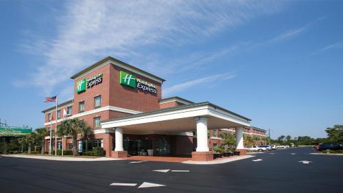 a building with a hotel on the side of a street at Holiday Inn Express Leland - Wilmington Area by IHG in Leland