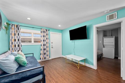 a living room with a couch and a flat screen tv at Bright and Cozy Med Center Apartment in Houston
