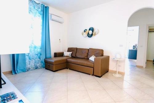 a brown couch in a living room with blue curtains at DV holiday home in Isola delle Femmine