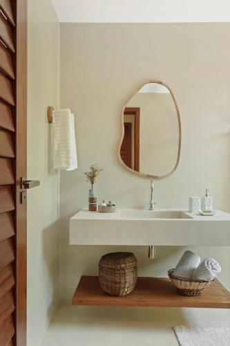 a bathroom with a sink and a mirror at Bahia Soul - Casas Maeva - Taipu de Fora - Península de Maraú in Barra Grande
