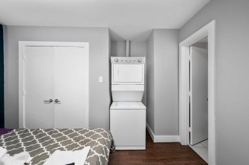 a kitchen with a refrigerator and a bed in a room at Bright and Cozy Med Center Apartment in Houston