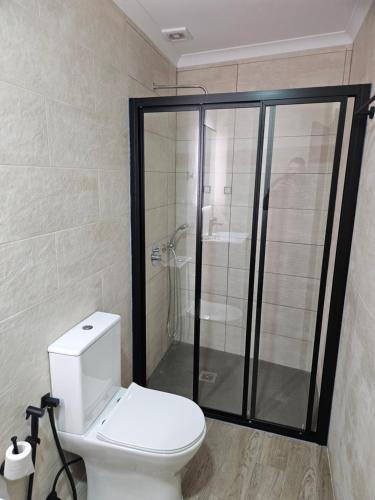 a bathroom with a toilet and a glass shower at Casa do Beco in Aldeia de João Pires
