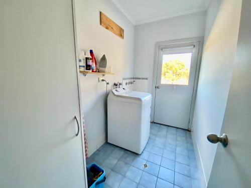 a white bathroom with a toilet and a sink at Kangaroo Island Cabins in Kingscote
