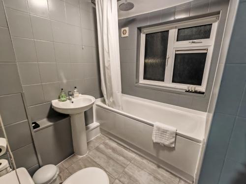 a bathroom with a sink and a toilet and a shower at Garland Modern Close To Station 3 Bedroom City Apartment in London