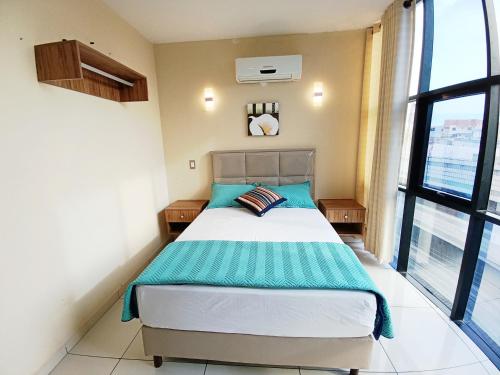 ein Schlafzimmer mit einem Bett und einem großen Fenster in der Unterkunft Centrico Espacio Cruceño Full in Santa Cruz de la Sierra