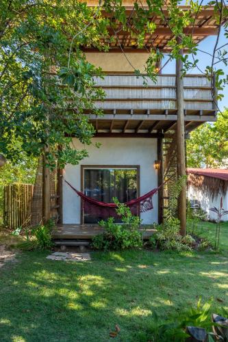 a house with a porch and a bench in the yard at Bahia Soul - Kawai Suítes - Taipu de Fora - Península de Maraú in Marau