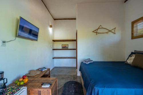 una stanza con un letto, un tavolo e una tv di Bahia Soul - Kawai Suítes - Taipu de Fora - Península de Maraú a Marau