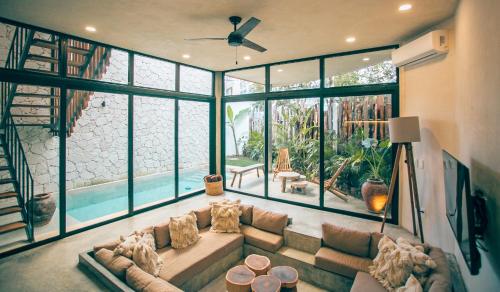 a large living room with a large couch and windows at Round Luxury Jungle Villa Priv Pool-Concierge 4A in Tulum