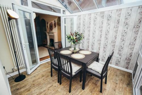 a dining room table with chairs and a vase of flowers at Huge 4 Bed Family Home in Derbyshire with Parking in Derby