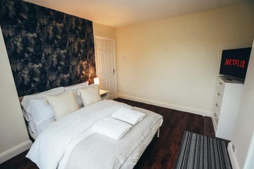 a white bed with white pillows in a room at Huge 4 Bed Family Home in Derbyshire with Parking in Derby