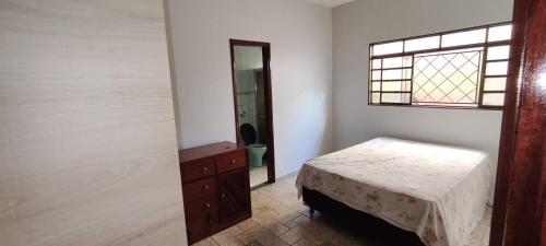 een slaapkamer met een bed, een ladekast en een spiegel bij Casa para tecnoshow 2025 rioverde in Rio Verde